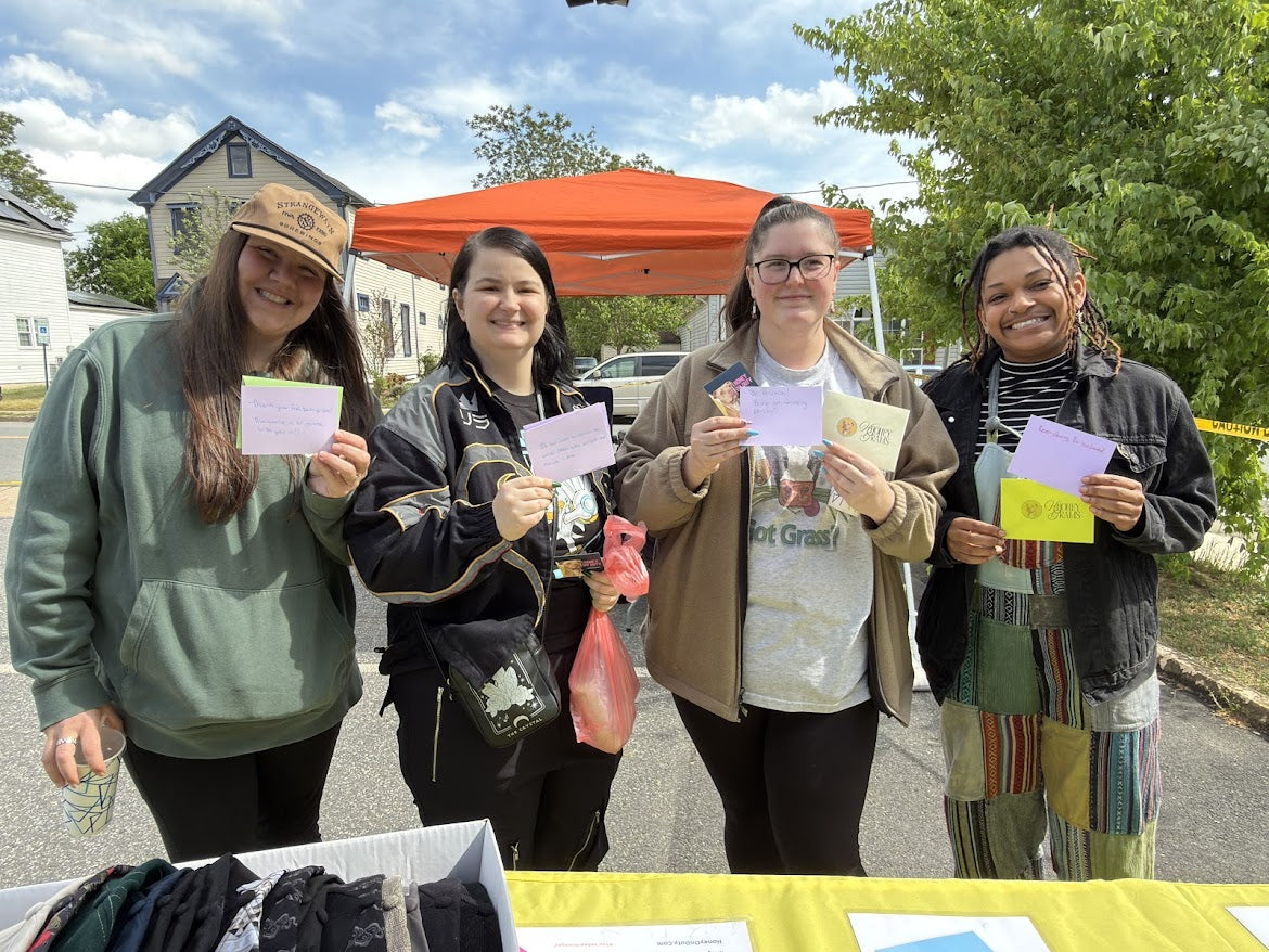 Supporters holding cards at a Honey On Duty community booth
