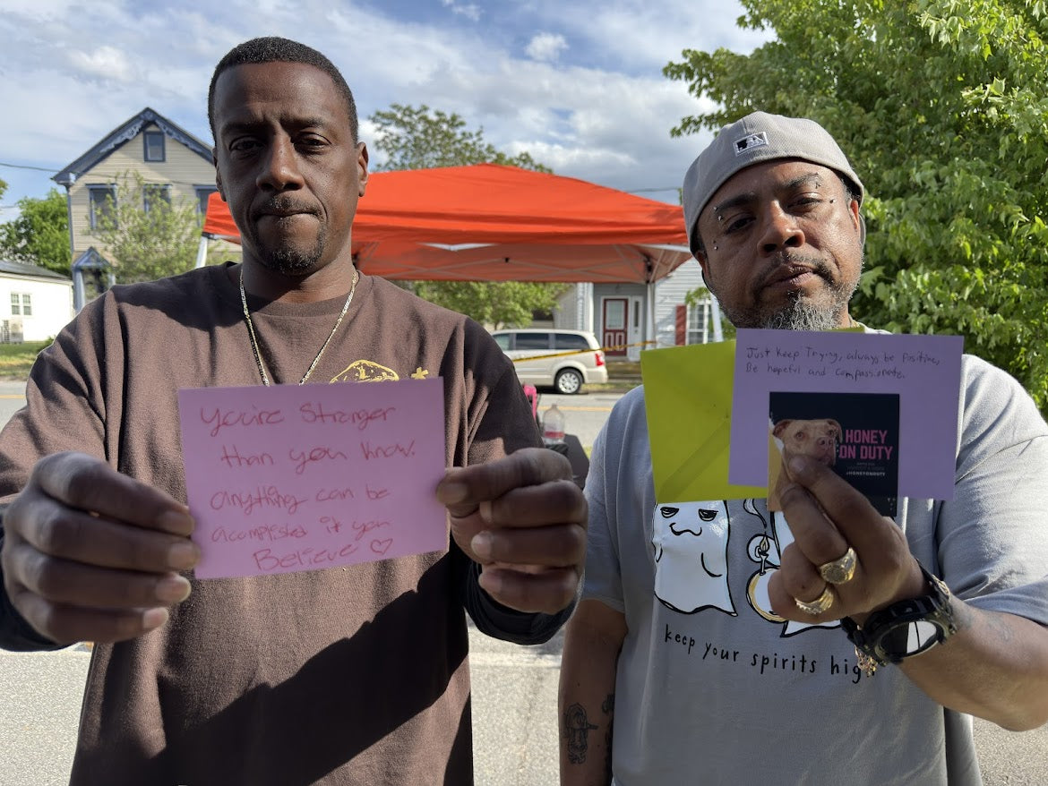 Community members holding inspirational signs at a Honey On Duty advocacy event