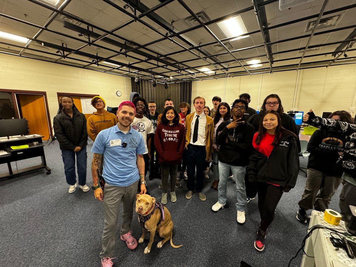 Honey the therapy dog visiting students during a school outreach event